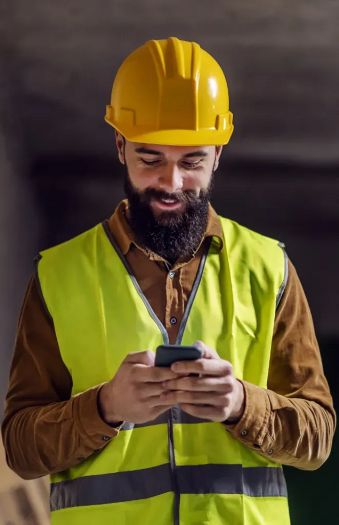 Construction worker searching for jobs on mobile phone