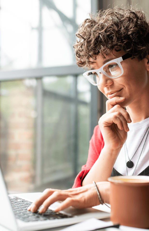 Recruitment Marketer in coffee shop reviewing packages on laptop screen